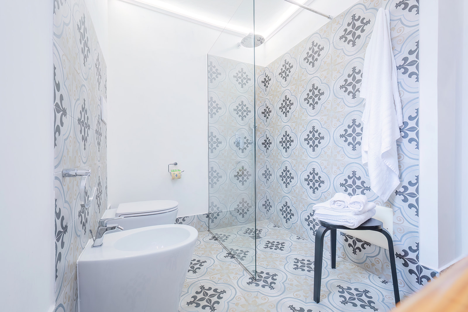 Bagno con cementine artigianali azzurro e beige, doccia walk-in in vetro