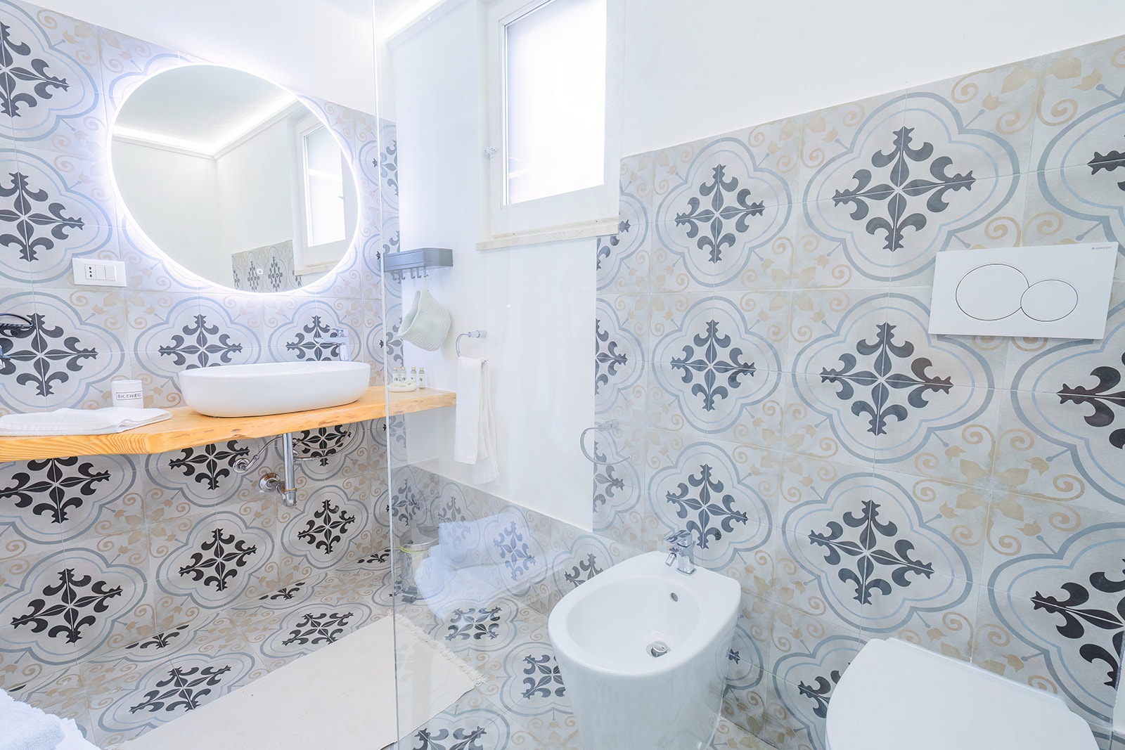 Secondo bagno con specchio retroilluminato e lavabo su mensola in legno