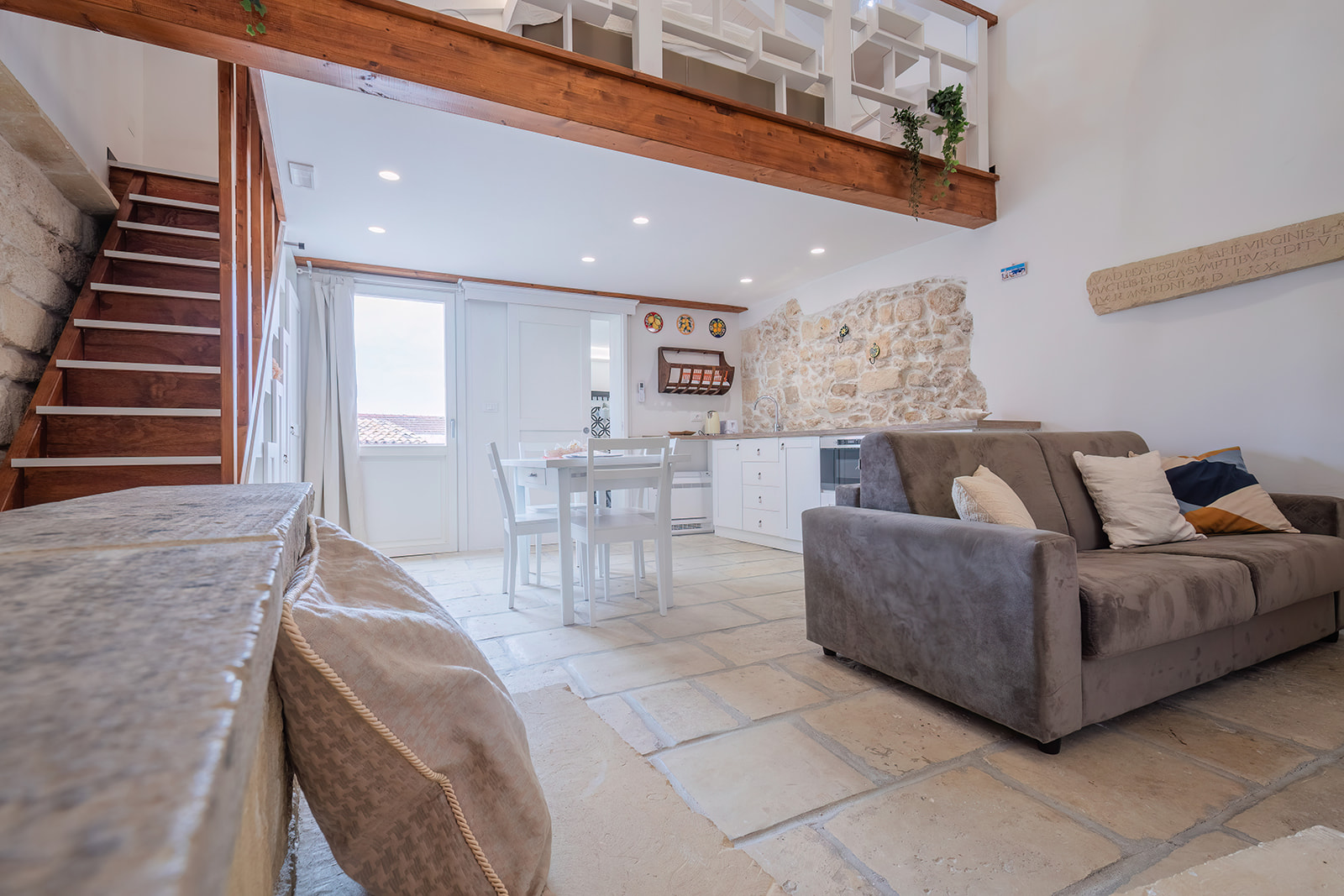 Soggiorno della seconda dimora con pavimento in chianche di pietra e lapide latina del 1580