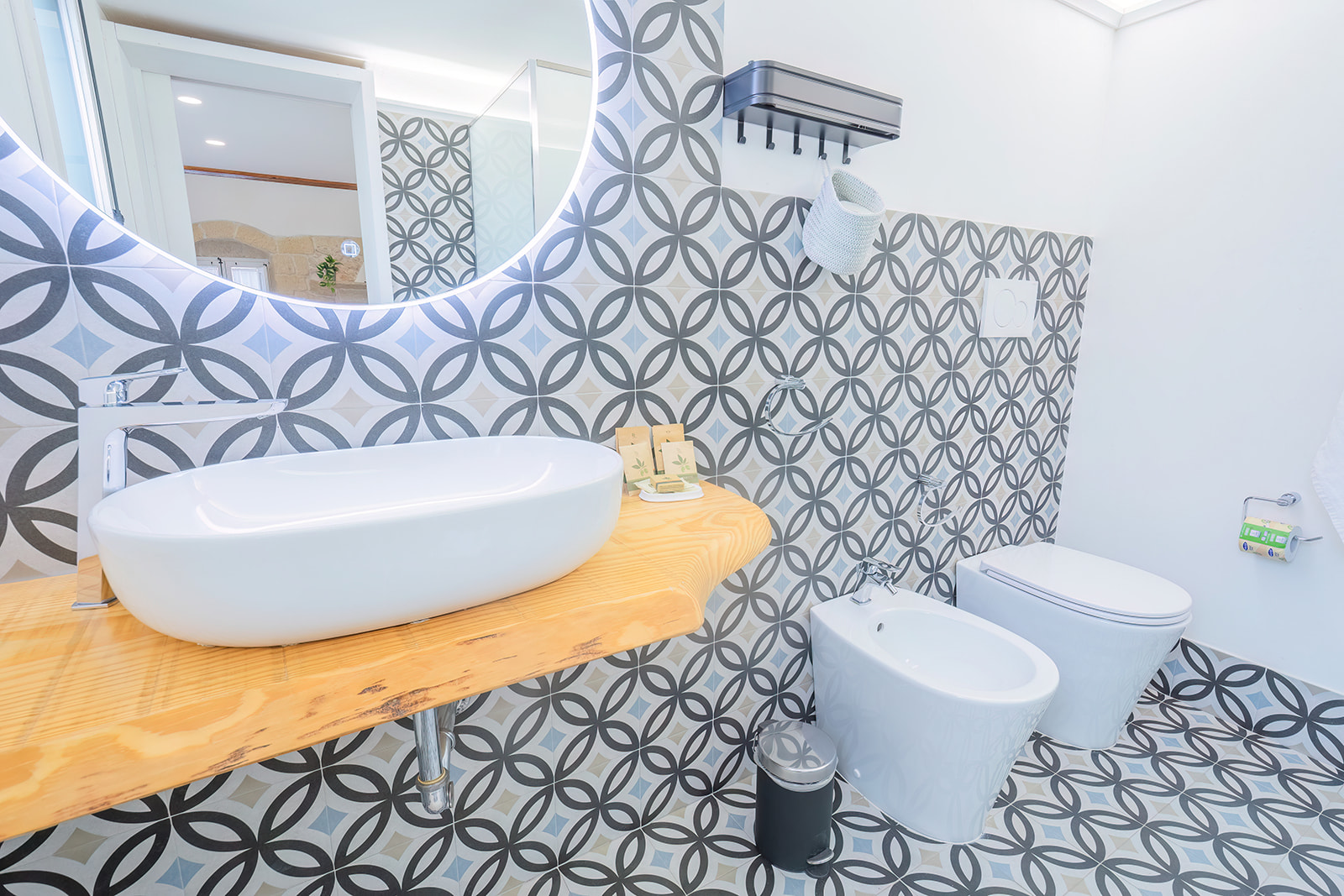 Bagno con cementine geometriche grigio e azzurro a cerchi intrecciati