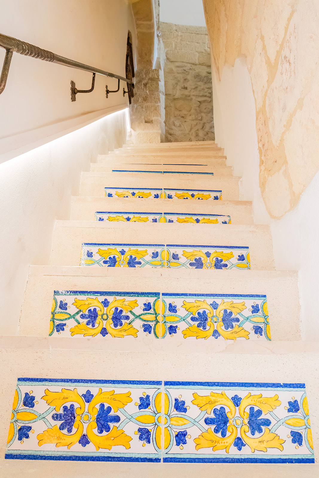 Scala in pietra con alzate decorate da maioliche dipinte blu e gialle