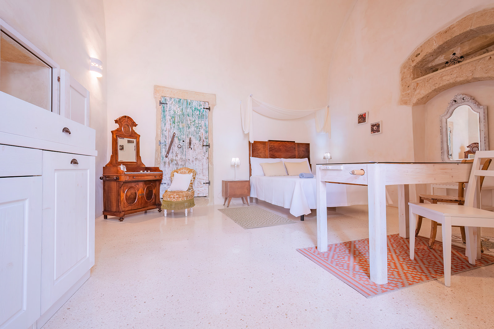 Camera della Dimora 1 con porta antica verde, cassettone in noce e letto matrimoniale