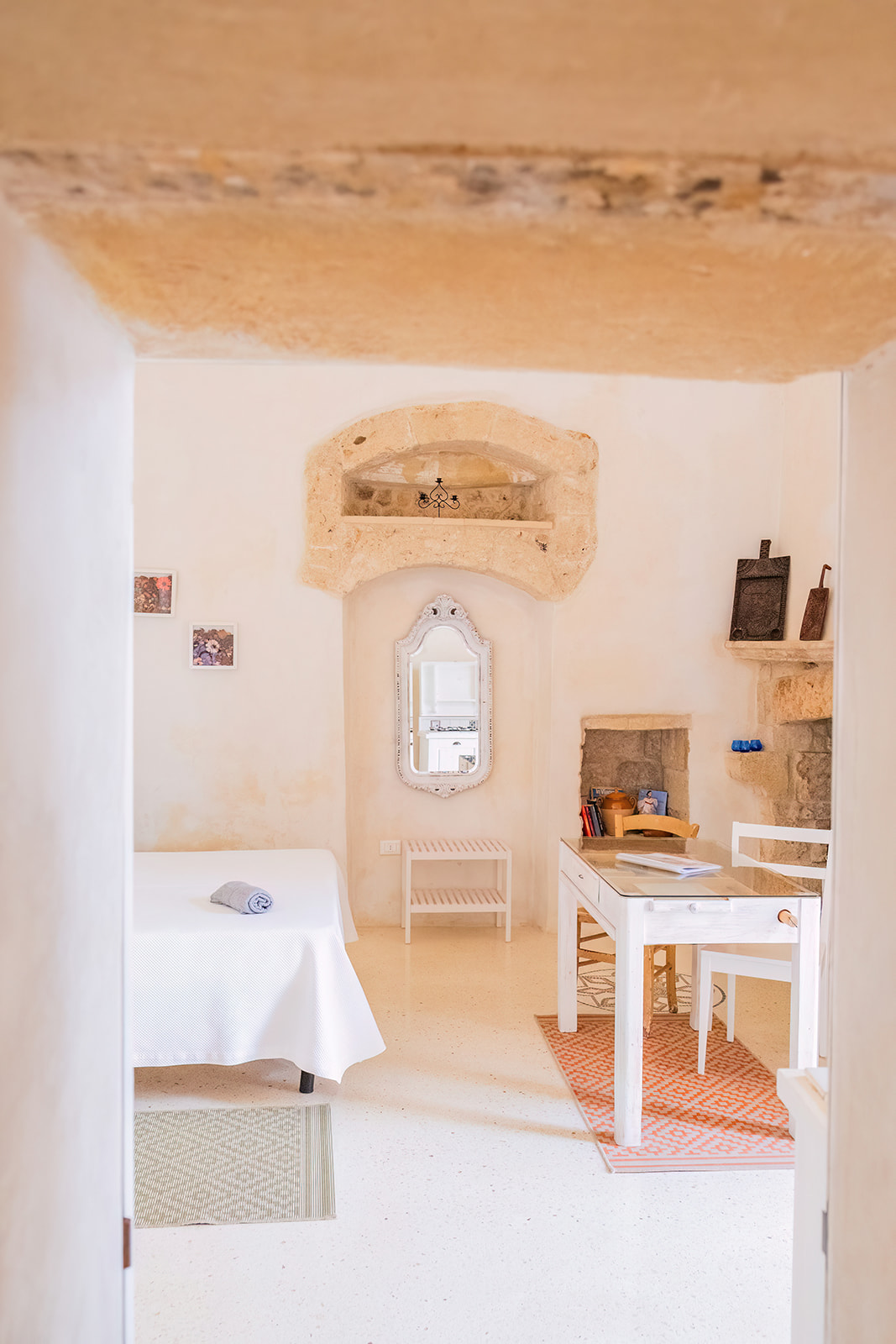 Vista d'insieme della Dimora 1 dalla soglia: scrivania, letto e specchio antico