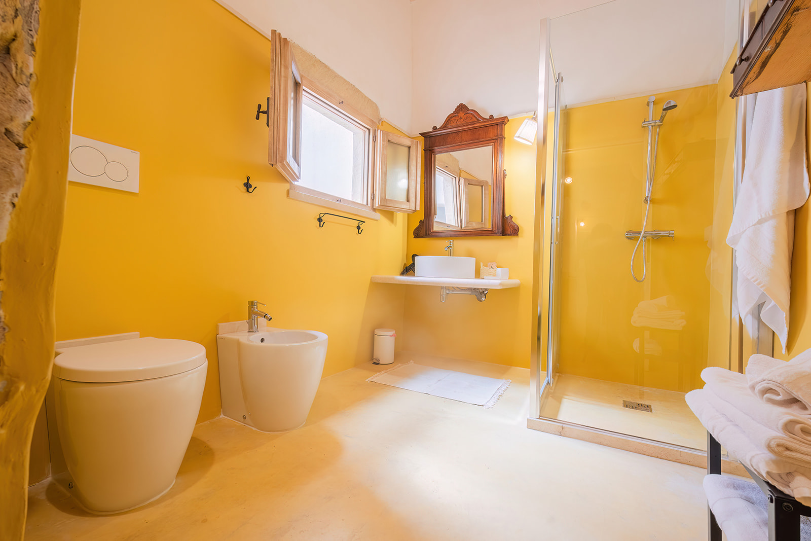 Bagno della Dimora 2 in giallo intenso con doccia in vetro e specchio antico